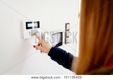 Young Woman Entering Security Code On Keypad
