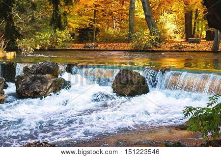 Waterfall in autumn in Munich city as background
