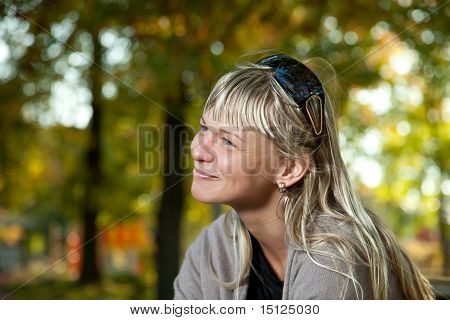 Mulher loira com óculos de sol retrato em um parque de outono.