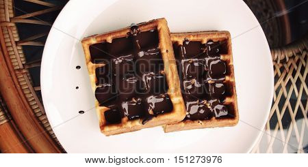 Vienna Waffles. Chocolate topping. Aged. View from the Top. White plate with Chocolate covered Wafers. Toned. Tasty dessert. Wide photo for wallpaper or site slider. Unhealthy but delicious.