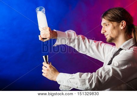 Entertainment alcohol bartending concept. Bartender pouring liquor into glass. Young tapster making a drink.