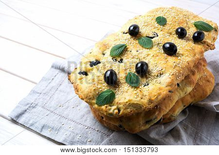 Italian bread focaccia focaccia with olive garlic and herbs. Homemade traditional Italian bread focaccia on the linen napkin.