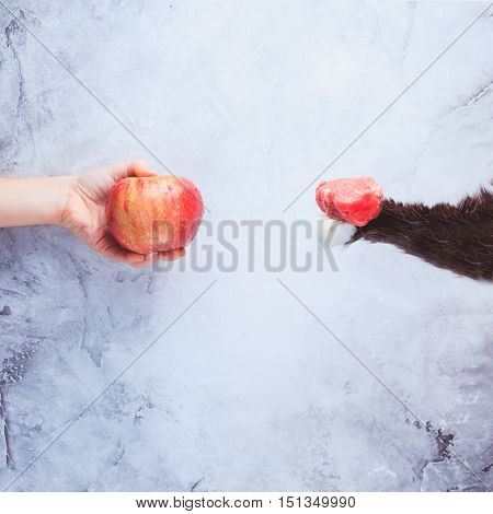 Go Vegan! Concept Of Veganism. Vegan Diet. Human Hand With Apple And Cat Paw With Meat.