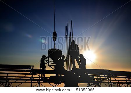 Silhouette construction industry team safely to work load concrete building according to set goal over blurred background sunset pastel for industry background.