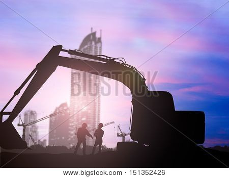 silhouette Loaders and construction worker in a building site over Blurred construction site