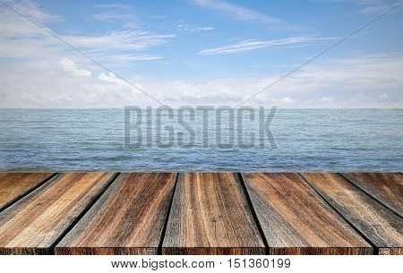 empty wood floor beside sea with blue sky background. summer relaxing time.