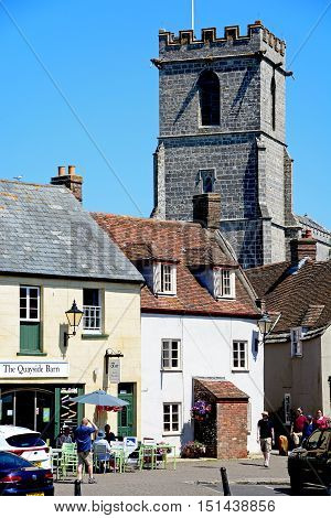 WAREHAM, UNITED KINGDOM - JULY 19, 2016 - Lady St Mary parish church tower seen above shop buildings Wareham Dorset England UK Western Europe, July 19, 2016.