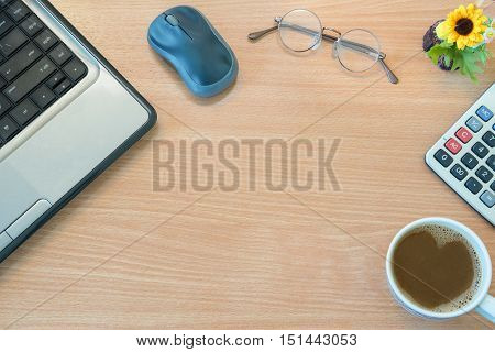 Top View Of Office Wooden Desk With Notebook Mouse Glasses Flower Calculator And Cup Of Coffee