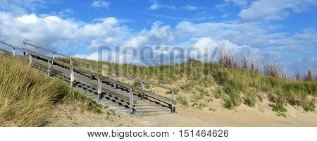sunny scenery including a sanddune with stairs in the Netherlands