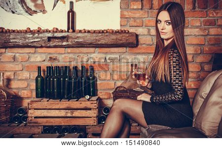Woman Tasting Wine In Rural Cottage Interior