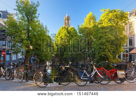 Dom Tower, canal and bridge with bikes in the sunny evening, Utrecht, Netherlands