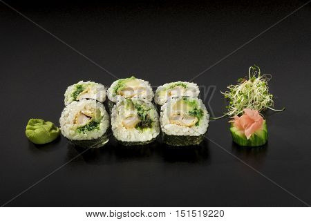 delicious Japanese sushi rolls decorated with seaweed salad and wasabi