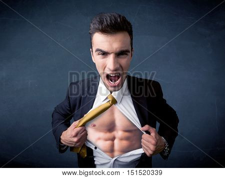 Businessman tearing off his shirt and showing mucular body concept on background