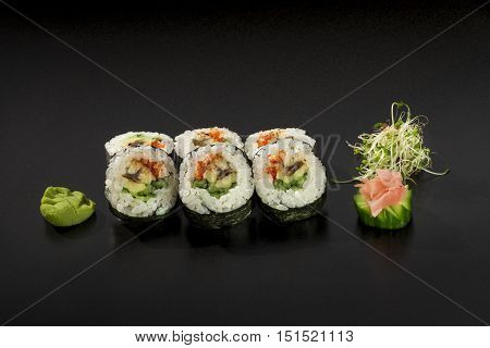 fresh made Japanese sushi rolls decorated with seaweed salad and wasabi