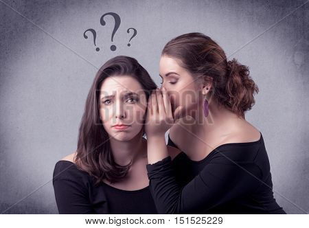 A teenager girl looking confused with drawn question marks above the head, while a girlfriend whispers something in her ear concept.