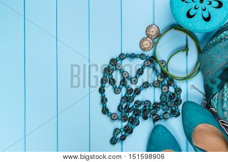 Set of fashionable women's acsessories on the blue wooden background.