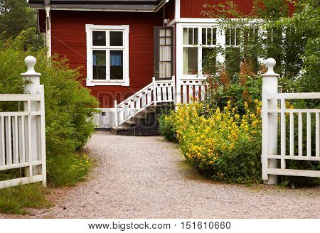 Entrance to a small typical red Swedish wooden house.