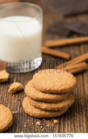 Biscuits with glass of milk on natural wooden table..