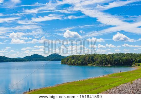 Summer view of local lake Cave Run with beautiful forest on lake hillside shore and dramatic cloudscape sky in Kentucky USA