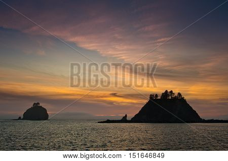 sunset over small islands in silhouette off the Washington coast on the La Push Native American Reservation USA