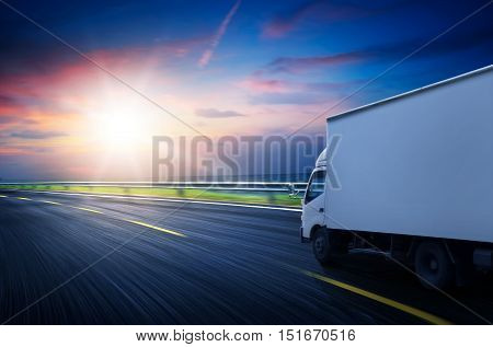 Truck traveling on road at sunrise - speed and delivery concept.