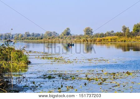 The river Chaus Kolyvan district Novosibirsk oblast Siberia Russia - September 17 2016: fishermen in an inflatable rowing boat with a spinning rod looking for a predatory fish on the river