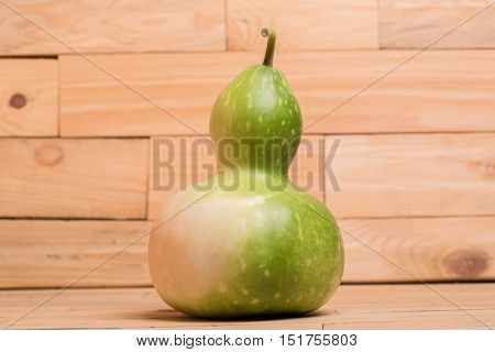 green calabash or Chinese Bottle Gourd is used by many cultures around the world for many different purposes, on a wooden table