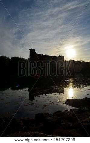 Amazing Dunvegan Castle silhouetted and reflecting in Loch Dunvegan.