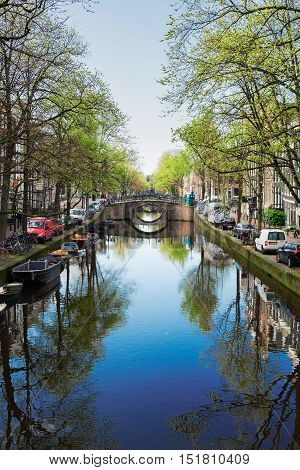 Bridge over canal with mirror reflections in water, Amstardam, Netherlands