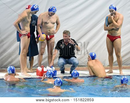 KAPOSVAR, HUNGARY - OCTOBER 5: Lajos Vad Honved trainer (in black) in action at a Hungarian championship water-polo game Kaposvar (white) vs. Honved (blue) on October 5, 2016 in Kaposvar, Hungary