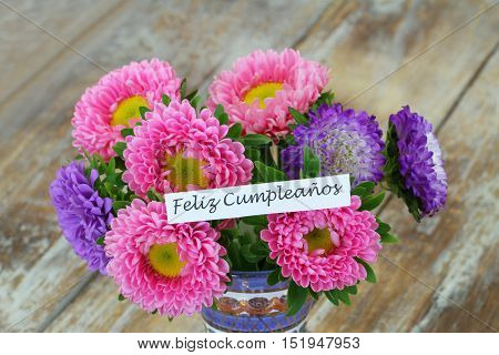 Feliz cumpleanos (which means happy birthday in Spanish) card with colorful daisy flower bouquet