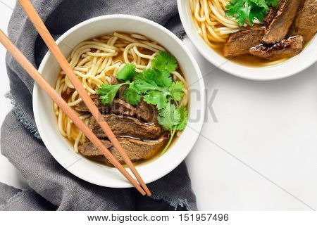 Noodles and beef in two bowls asian meal top view