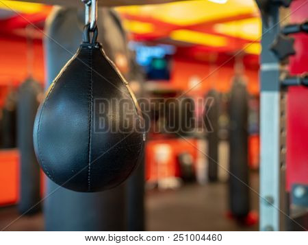 A Black Leather Speedbag, With Muay Thai Bags In The Back, Ready For Use In A Gym