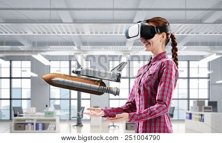Young Caucasian Woman In Modern Office Interior Trying Virtual Reality Helmet And Viewing Space Shut