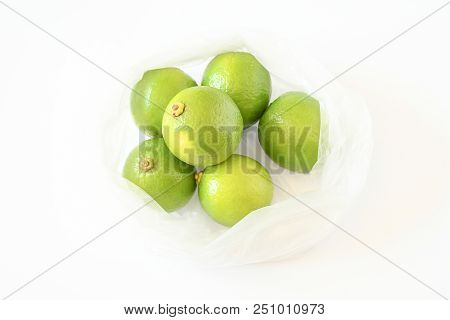 Freshness Top View Of Green Limes Put In Plastic Bag On White Background And Vegetable Full With Nut