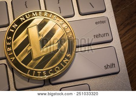 Close Up New Gold Litecoins With Light Reflex, Coin Put On Modern Keyboard That Show Enter, Return A
