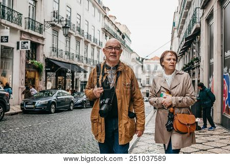Portugal, Lisbon, 01 May 2018: An Elderly Couple Of European Tourists Walking Around The City.