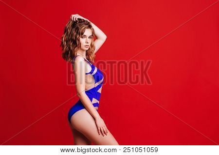Pretty Bikini Model In Studio On Red Background