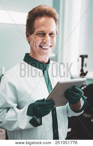 Scientist In Labcoat. Promising Scientist Wearing White Labcoat Smiling Broadly While Standing In Mo