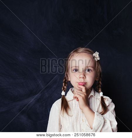 Сurious Child Thinking. Little Girl On Chalk Board Background With Copy Space. Back To School, Kid C