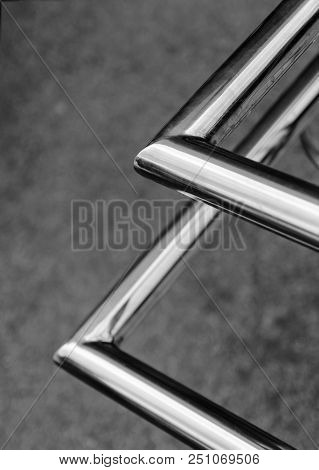 Polished Stainless Pipes Welded At An Angle. Gray Industrial Background. Diagonal.