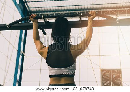 Fitness Woman Exercising On Chin-up Bar. Athlete Girl Doing Chin-ups Training