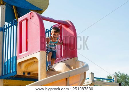 A Joyful Boy Skate On A Children's Roller Coaster In The Park.