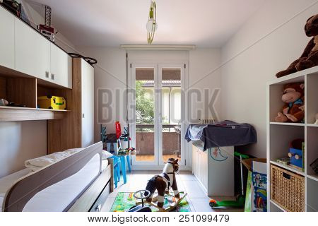 Child bedroom with many games on the ground. Nobody inside