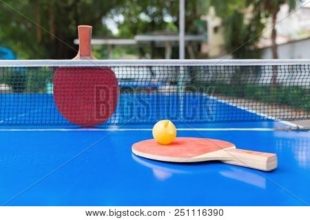 Pingpong Rackets And Ball And Net On A Blue Pingpong Table