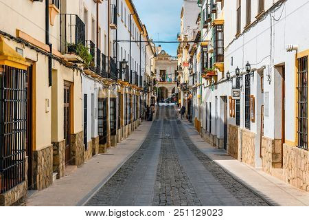 Ronda, Spain, April 05, 2018: Narrow Street With White Facades Of Houses In Historic District Of Ron