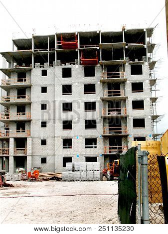 Building Under Construction With Contruction Equipment Laying Around And The Enter And Exit Gate Ope