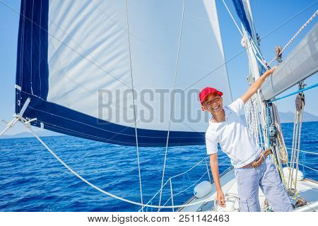 Cute Boy On Board Of Sailing Yacht On Summer Cruise. Travel Adventure, Yachting With Child On Family