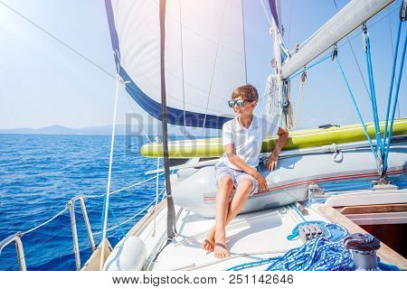 Cute Boy On Board Of Sailing Yacht On Summer Cruise. Travel Adventure, Yachting With Child On Family