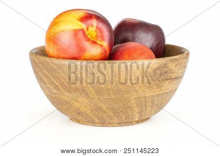 Lot Of Whole Ripe Deep Red Nectarine In A Wooden Bowl Isolated On White